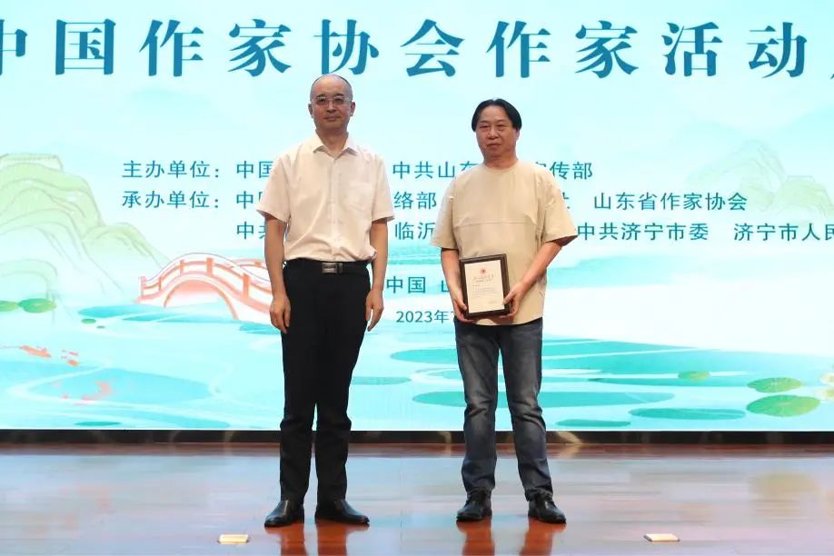 張宏森、吳義勤向參加此次“作家活動周”的中國作協(xié)會員逐一頒發(fā)專屬“入會紀念牌”