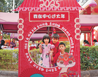 老撾民眾在“歡樂春節(jié)”廟會(huì)現(xiàn)場設(shè)立的新春祈福打卡點(diǎn)拍照。  坎帕頌攝